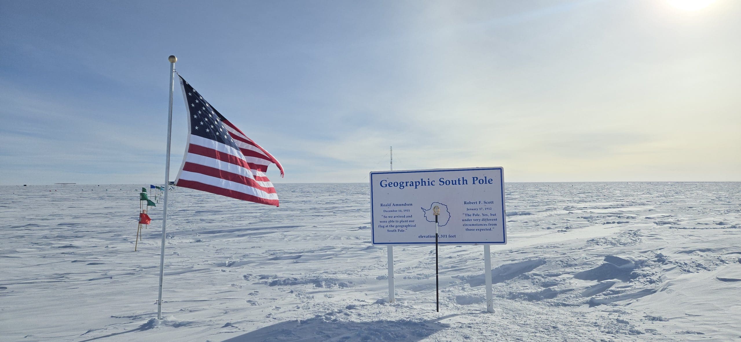 Geographic South Pole in Antarctica with an American flag waving in the wind